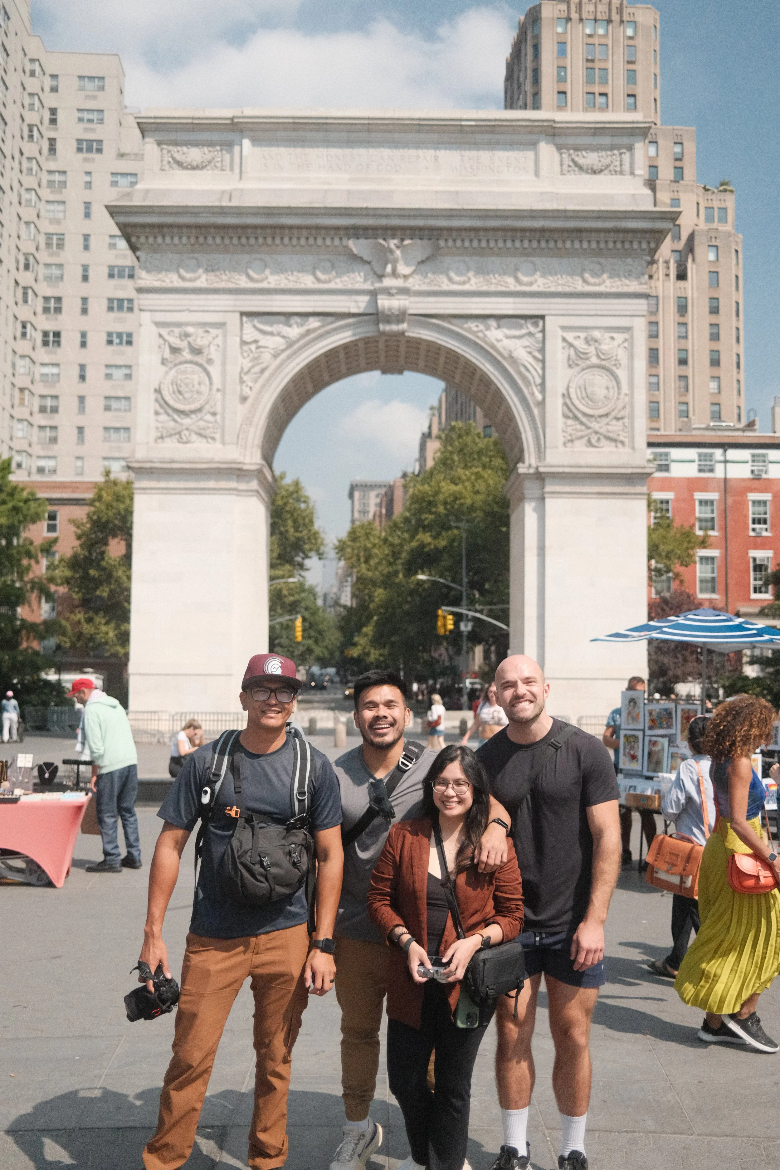 Four friends posing in front of the Washington Square Arch in New York