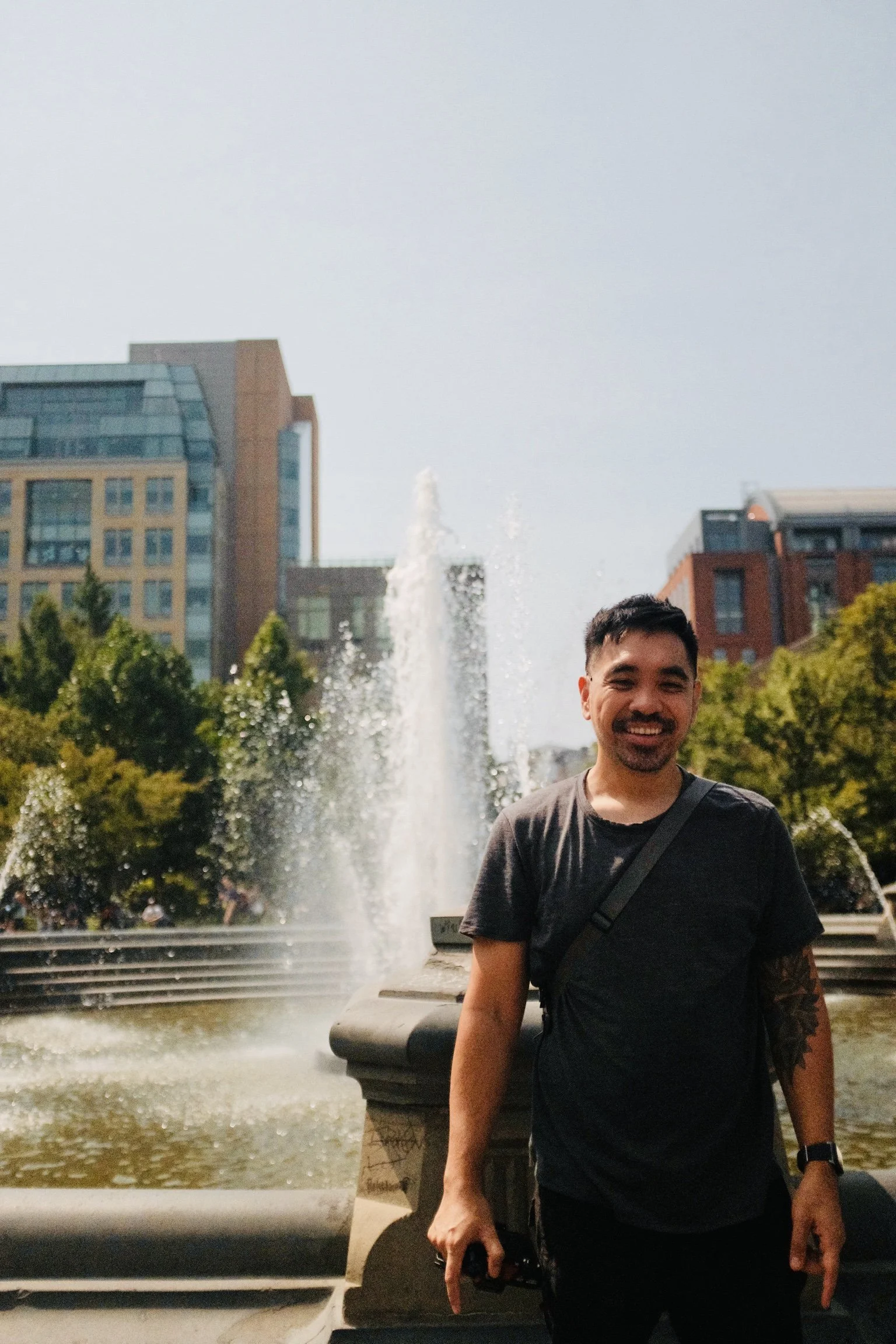 Mark smiling in front of the Washington Square Park fountain