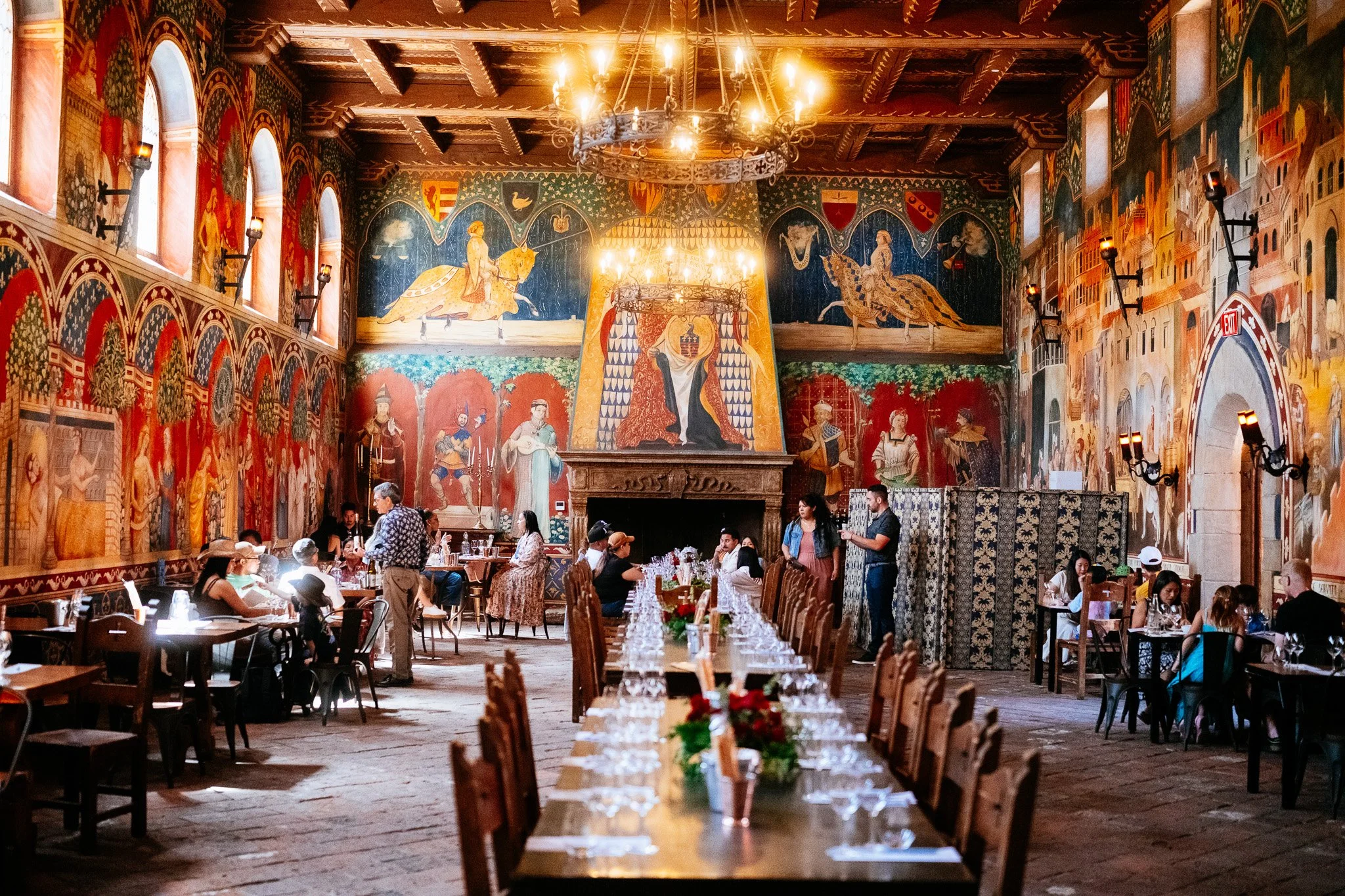 Fresco-covered great hall at Castello di Amorosa set with long wine tasting tables