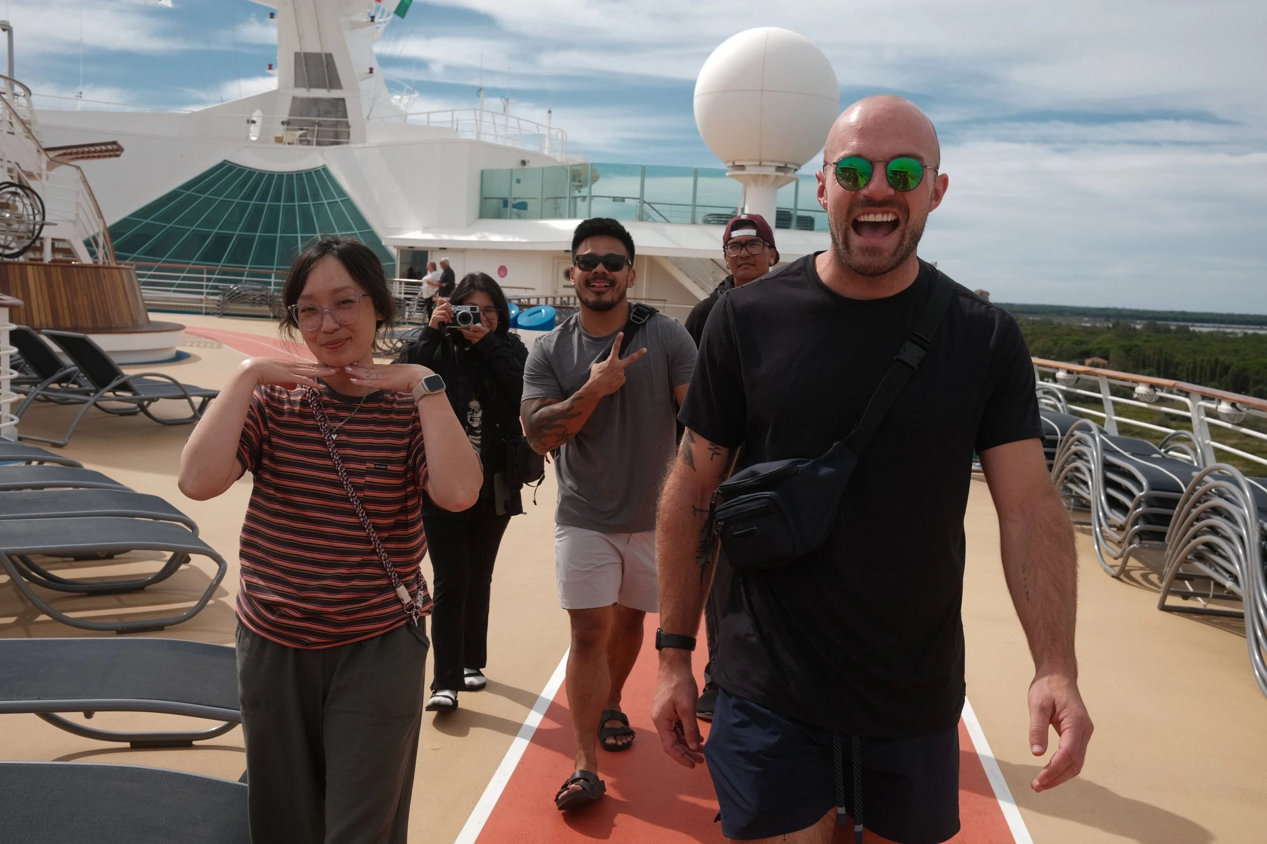 Friends walking the top-deck jogging track of a cruise ship