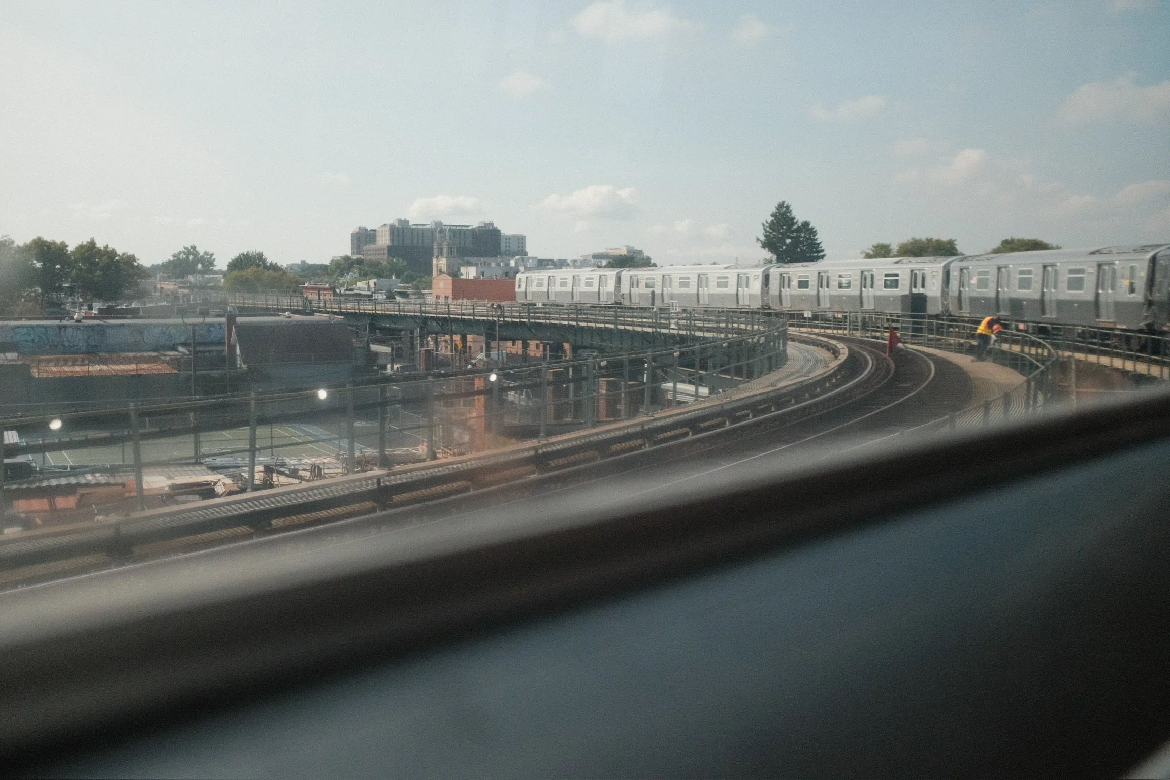 Elevated New York subway train curving along the tracks, seen from a train window